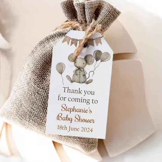 Gift bag with a decorative tag for a baby shower, featuring balloons and text.