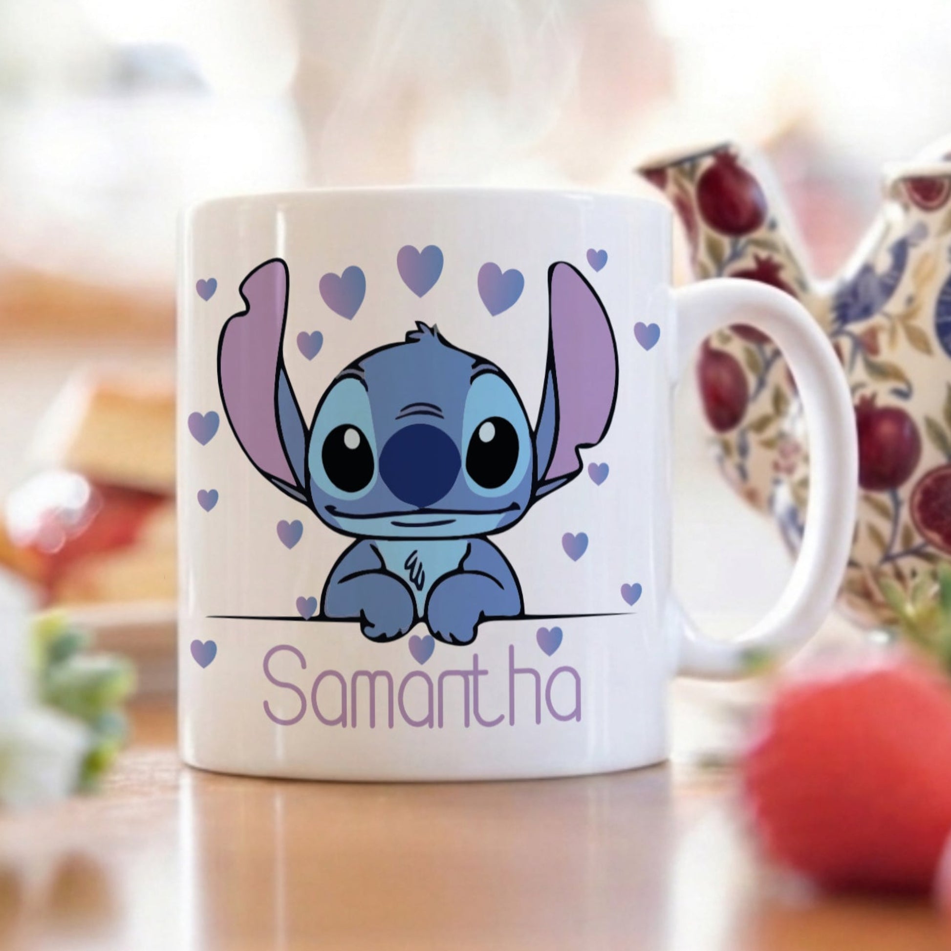 Cute cartoon character mug with 'Samantha' on a table with a teapot and fruits.