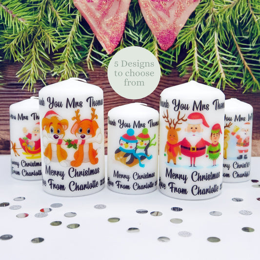 Set of personalized Christmas-themed candles with festive designs on a table with confetti.