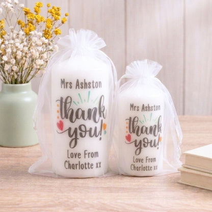 Two personalised white candles with printed 'Thank you' messages, customised with names and the expression 'Love from Charlotte.'.