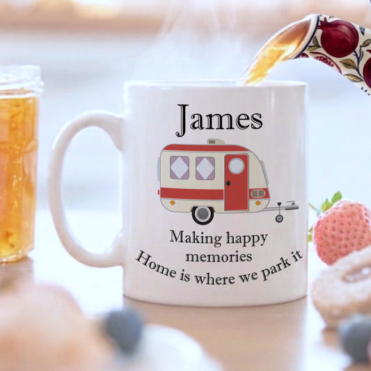 A white mug with a caravan design and the name James on it, on a breakfast table 