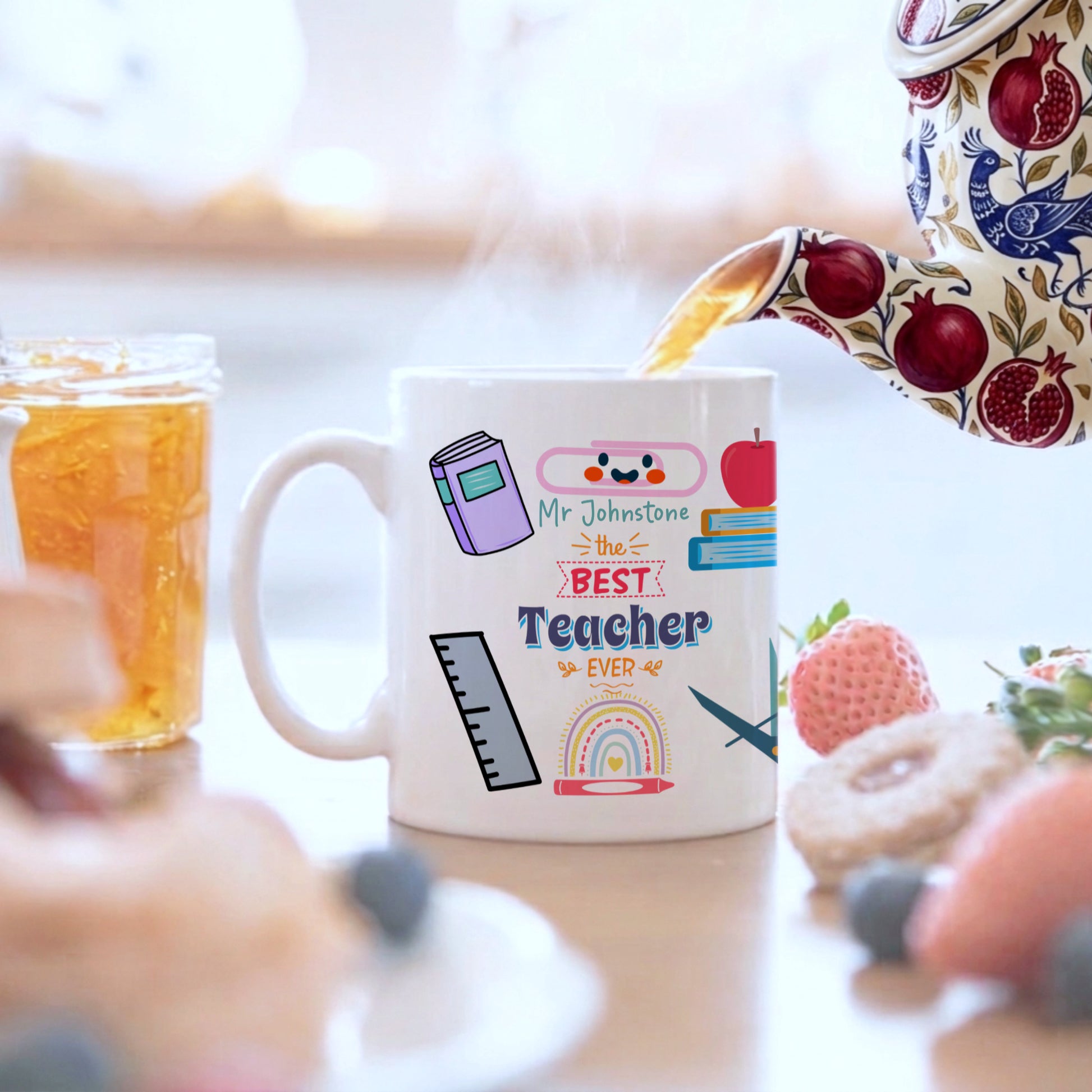 Mug with 'Best Teacher Ever' text and graphics, being filled with tea.