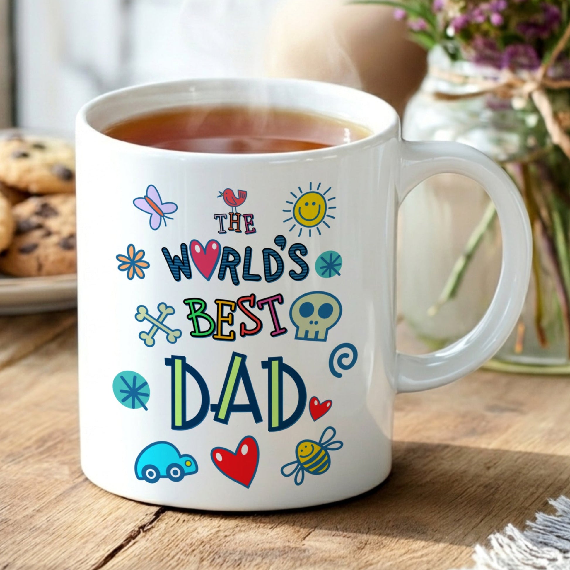 Mug with 'The World's Best Dad' text on a wooden table with cookies and flowers.