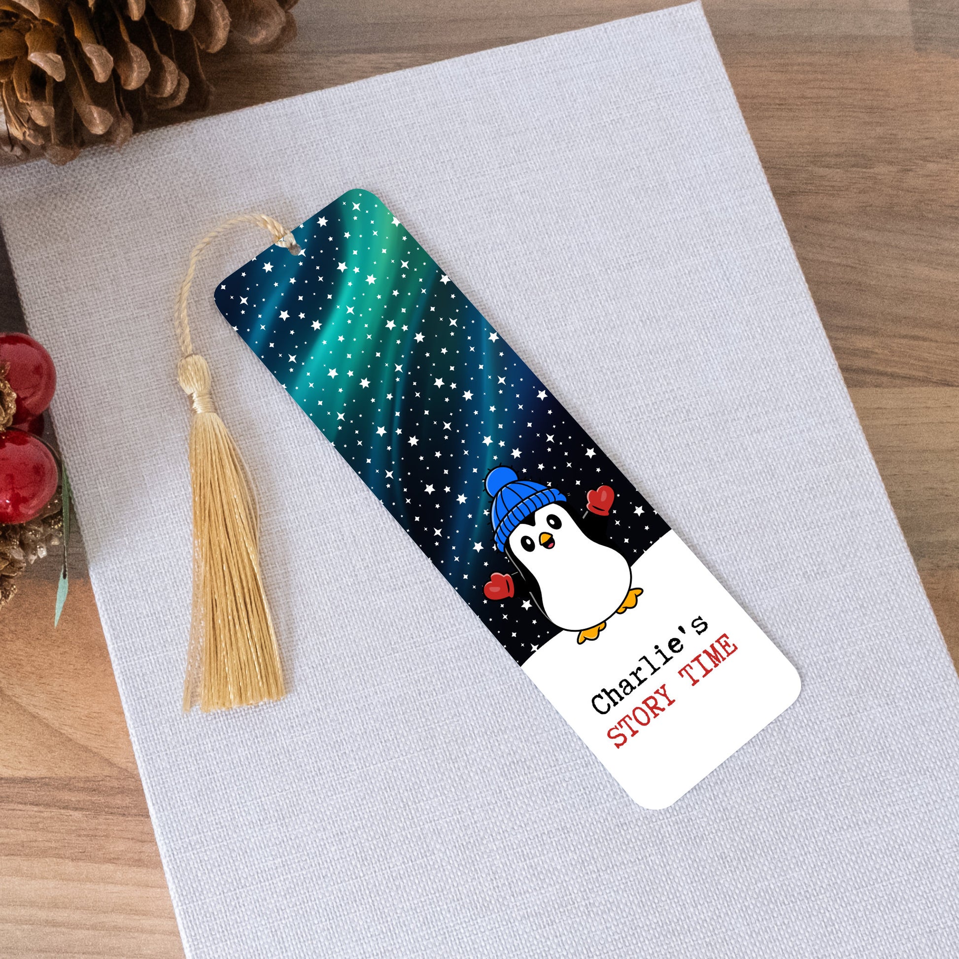 Personalized bookmark with penguin design and tassel on a textured surface