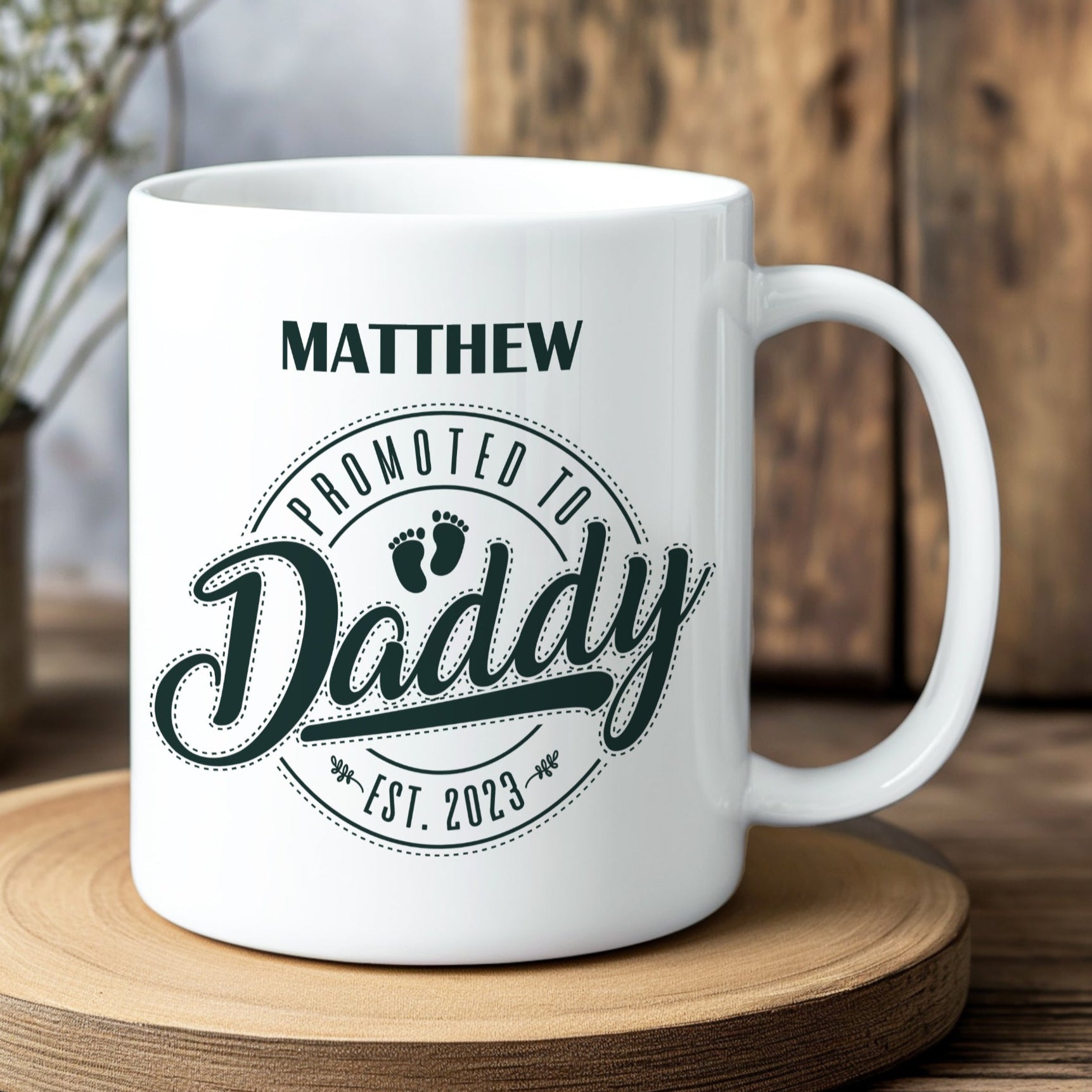 White mug with 'Promoted to Daddy' text on a wooden coaster