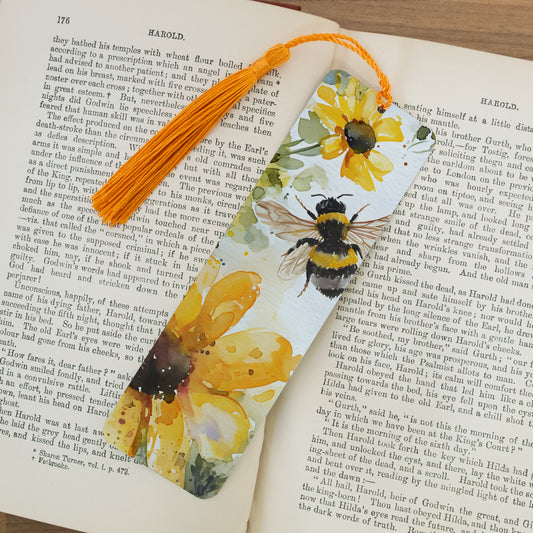 Bookmark with bee and flower design on an open book