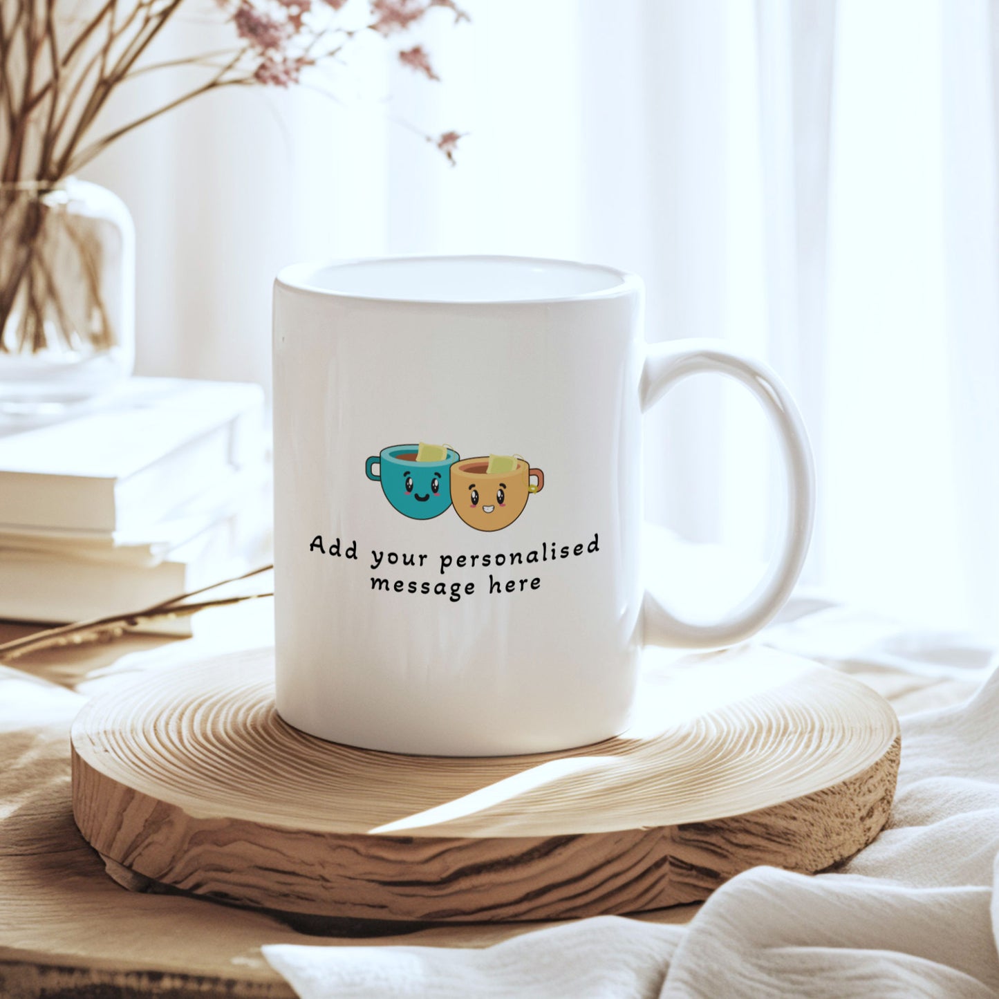 A white ceramic mug with a cute graphic of two smiling coffee cups and the text 'Add your personalised message here', displayed on a round wooden slice coaster in a bright, softly lit setting.