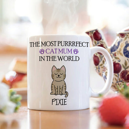 White mug with cat illustration and text on a blurred background
